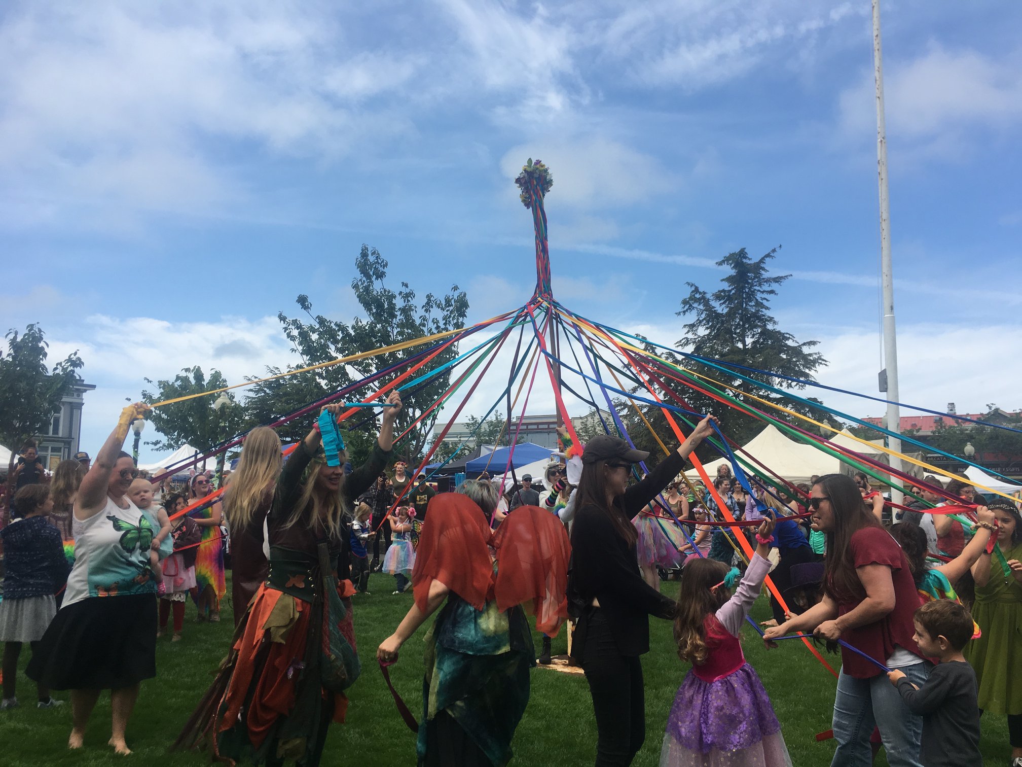 Fairy Festival attendees dance around a Maypole